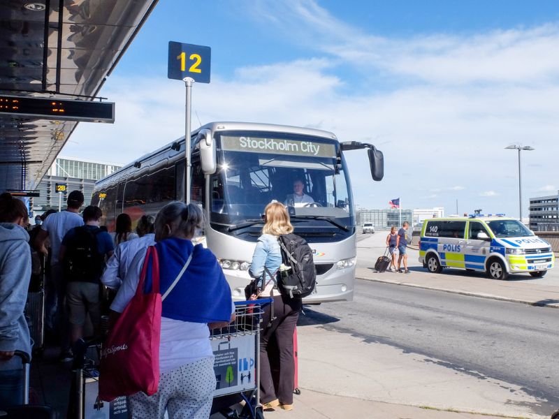 Touristen warten vor Bus für Transfer vom Flughafen Stockholm in die Innenstadt