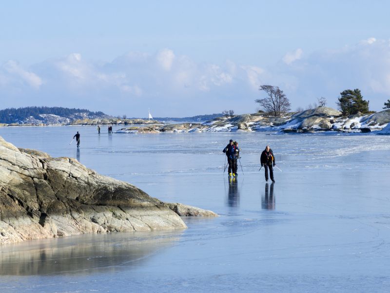 Menschen auf gefrorenem Wasser im Schärengarten von Stockholm im Winter